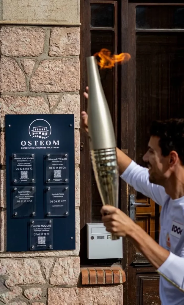 Plaque professionnelle cabinet d’ostéopathie avec identité visuelle sur façade en pierre